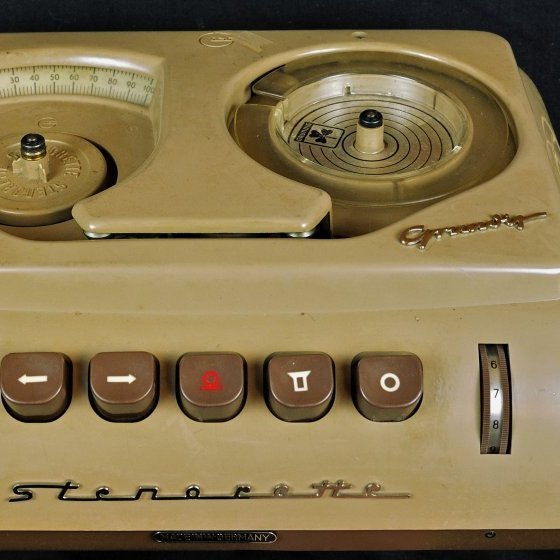 Grundig Stenorette diktafónn. Nr. 279334. Bjarni notaði þennann diktafón til að lesa inn ræður, greinar o.fl. sem síðan var afritað. ann hafði til dæmis þá vinnuvenju þegar hann skrifaði Reykjavíkurbréf Morgunblaðsins að lesa inn á diktafóninn á fimmtudögum. Svo var farið með það til afritunar og lesið yfir á föstudögum. Prófarkir þurftu að vera komnar til Morgunblaðsins fyrir hádegi á laugardögum og Reykjavíkurbréfið kom svo í sunnudagsblaði Morgunblaðsins.