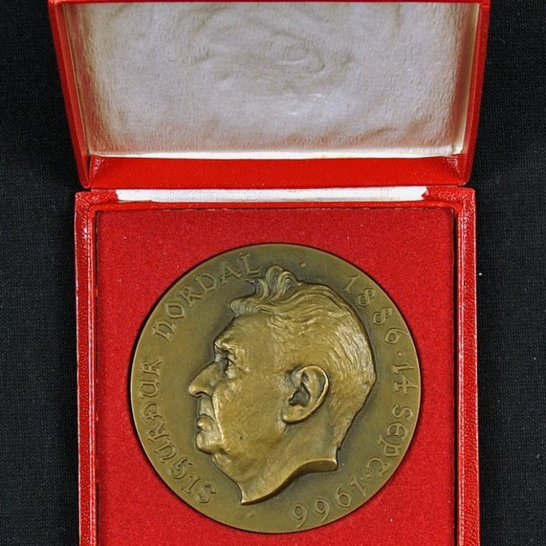 Á framhlið peningsins stendur: Sigurður Nordal 1886 14. sept. 1966.