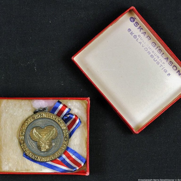 Askja með peningi og silkiborða.

Á framhlið peningsins stendur: HEIMDALLUR. FÚF. 16. FEBRÚAR 1927, 16. FEBRÚAR 1947.

Á bakhlið peningsins stendur: BJARNI BENEDIKTSSON UTANRÍKISRÁÐHERRA.