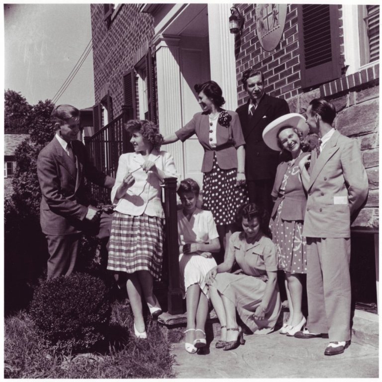 Um 1943 Fyrir utan sendiráð Íslands í Washington. Frá vinstri: Þórhallur Ásgeirsson, Marta Thors, Ágústa Ingólfsdóttir Thors, Thor Thors, Gígja Björnsson, Henrik Sv. Björnsson. Sitjandi til hægri er Margrét dóttir Thors og Ágústu en hin konan er ekki þekkt.