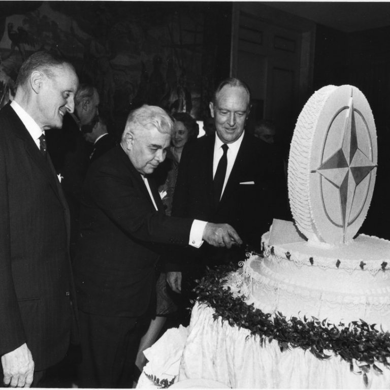 20 ára afmæli NATO 1969 - Bjarni Benediktsson forsætisráðherra sker afmælistertuna- Manlio Brosio Secretary General of  NATO til vinstri og Secretary Rogers til hægri (Ljósmyndari óþekktur © IPS)