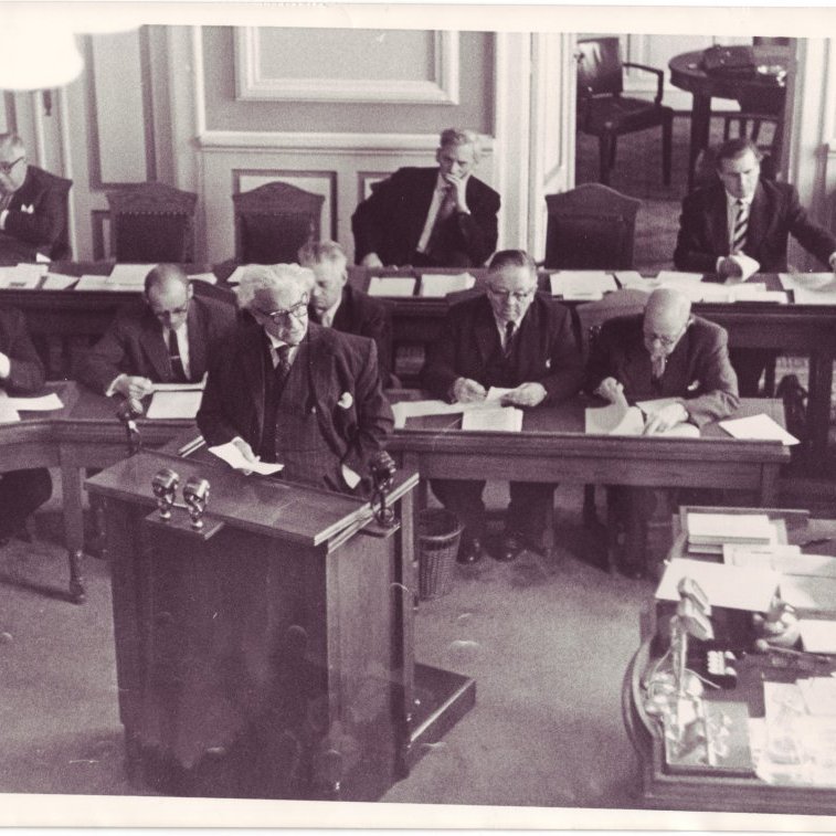 Ólafur Thors í ræðustól á Alþingi. Aftari röð frá hægri: Bjarni Benediktsson, Kjartan Jóhannsson, og Jóhann Hafstein. Fremri röð frá hægri: Sigurður Bjarnason frá Vigur, Sigurvin Einarsson, óþekktur, Karl Kristjánsson, óþekktur, Friðjón Þórðarson yst til hægri.