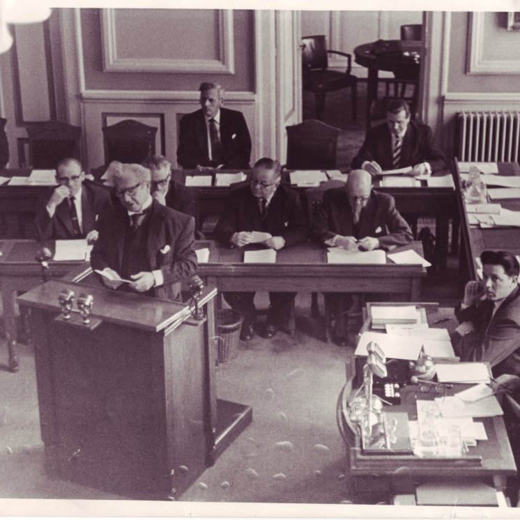 Ólafur Thors í ræðustól á Alþingi. Aftari röð frá hægri: Bjarni Benediktsson, Kjartan Jóhannsson, og Jóhann Hafstein. Fremri röð frá hægri: Sigurður Bjarnason frá Vigur, Sigurvin Einarsson, óþekktur, Karl Kristjánsson, óþekktur, Friðjón Þórðarson yst til hægri.