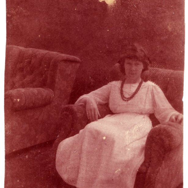 Um 1918 Kristjana Jensen í hægindastól bak við Fríkirkjuveg 11.